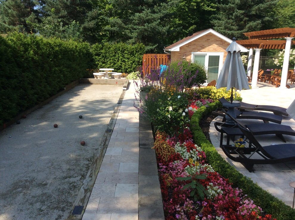 Example of a mid-sized trendy backyard stone patio design in Cleveland with no cover