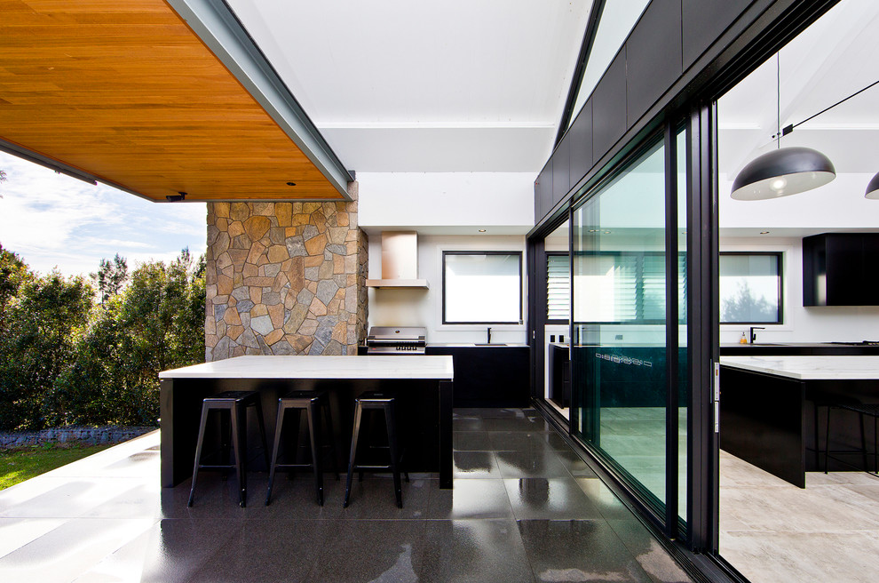 Photo of a large contemporary back patio in Sydney with an outdoor kitchen, a roof extension and tiled flooring.