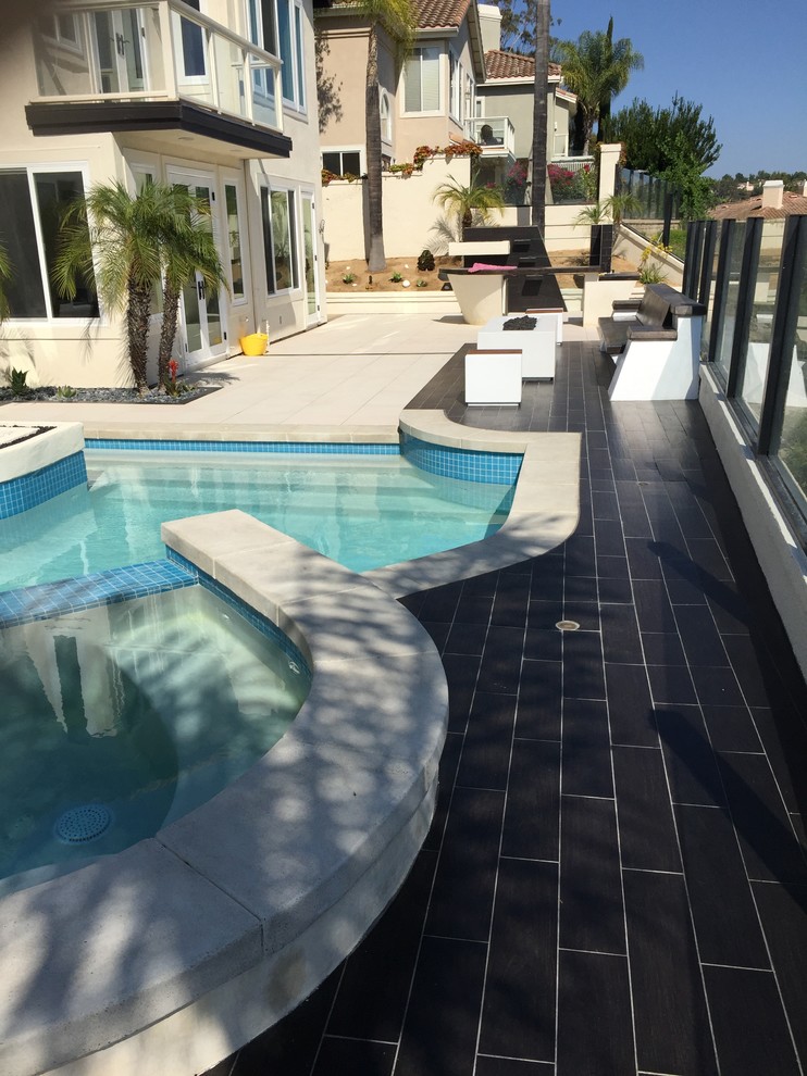 Medium sized contemporary back patio in San Diego with a fire feature, tiled flooring and no cover.