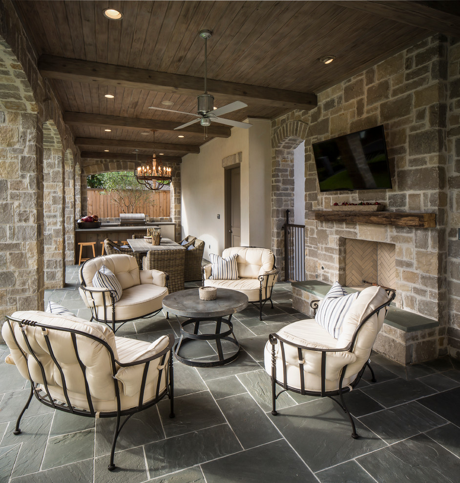 Idée de décoration pour une terrasse tradition avec un foyer extérieur et une extension de toiture.