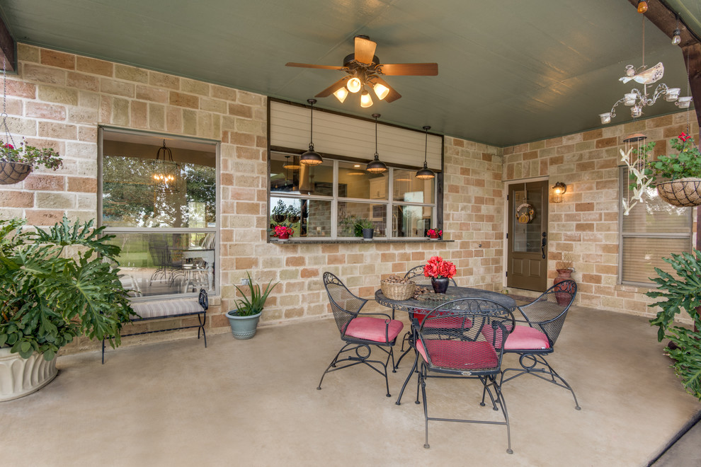 Immagine di un grande patio o portico country dietro casa con un tetto a sbalzo