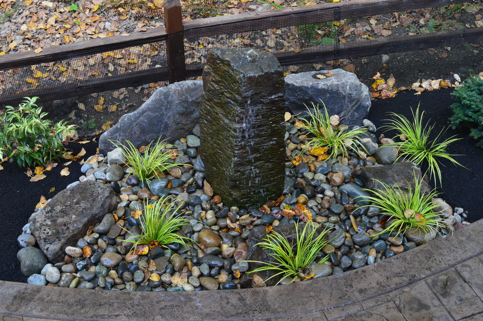 This is an example of a mid-sized craftsman backyard water fountain landscape in Seattle.