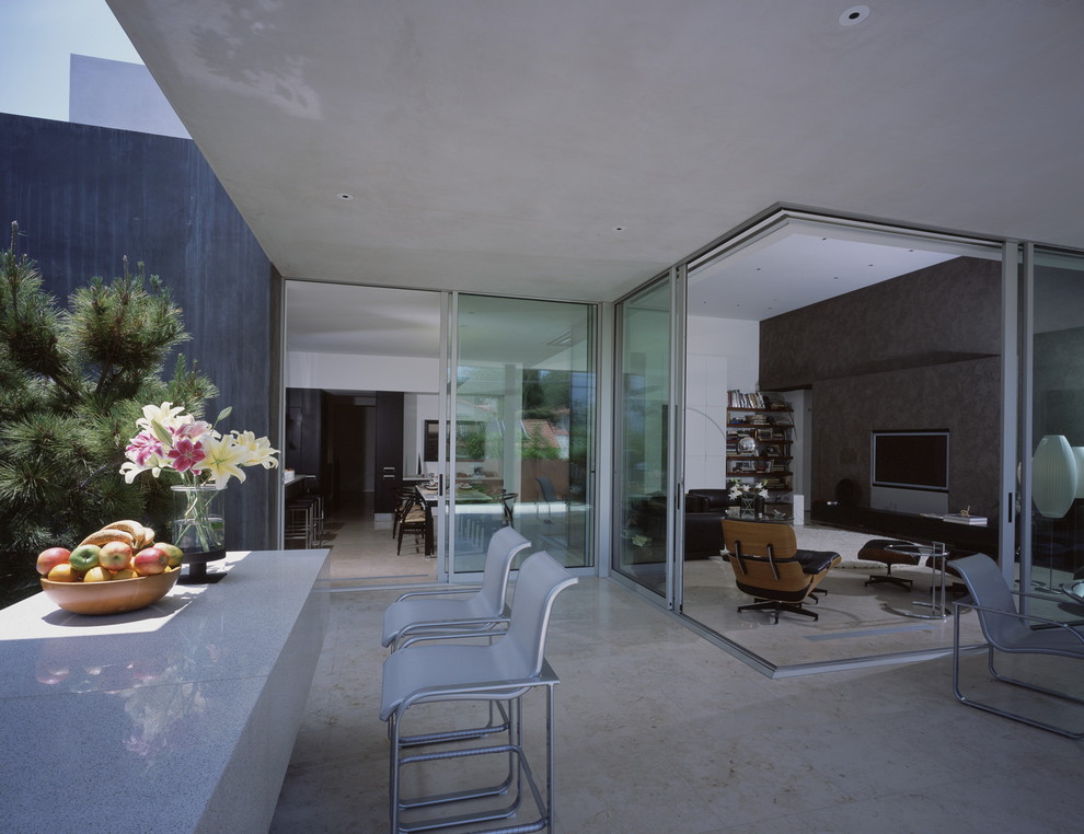 Esempio di un patio o portico minimalista con lastre di cemento e un tetto a sbalzo