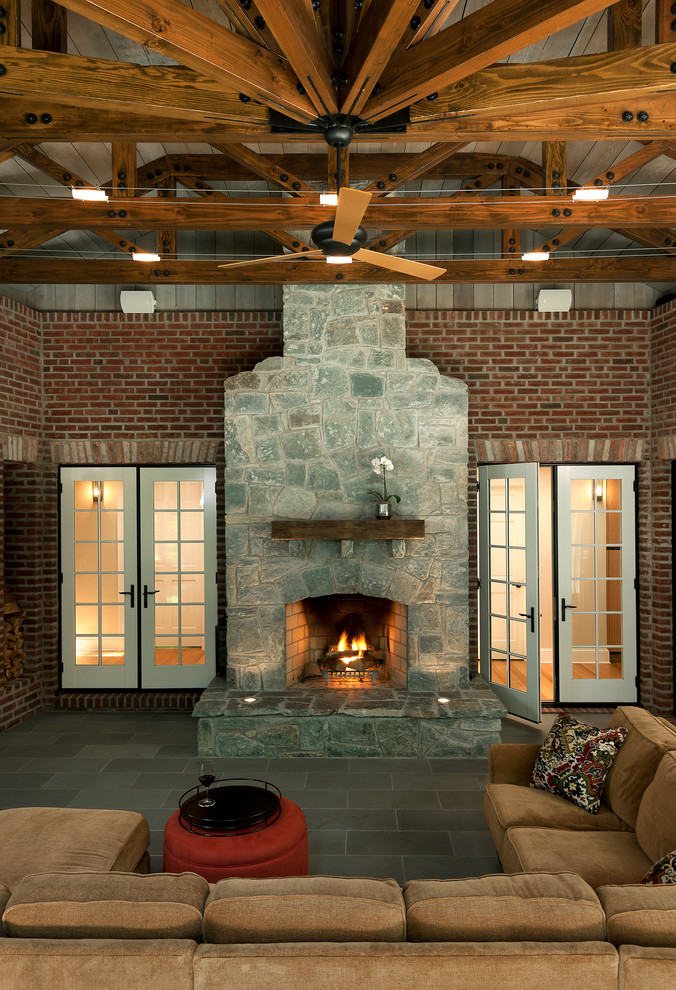 Стильный дизайн: большой двор в классическом стиле с покрытием из плитки, навесом и уличным камином - последний тренд