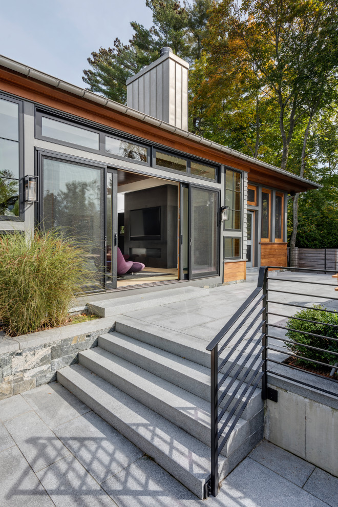 Diseño de patio contemporáneo sin cubierta en patio lateral con adoquines de piedra natural