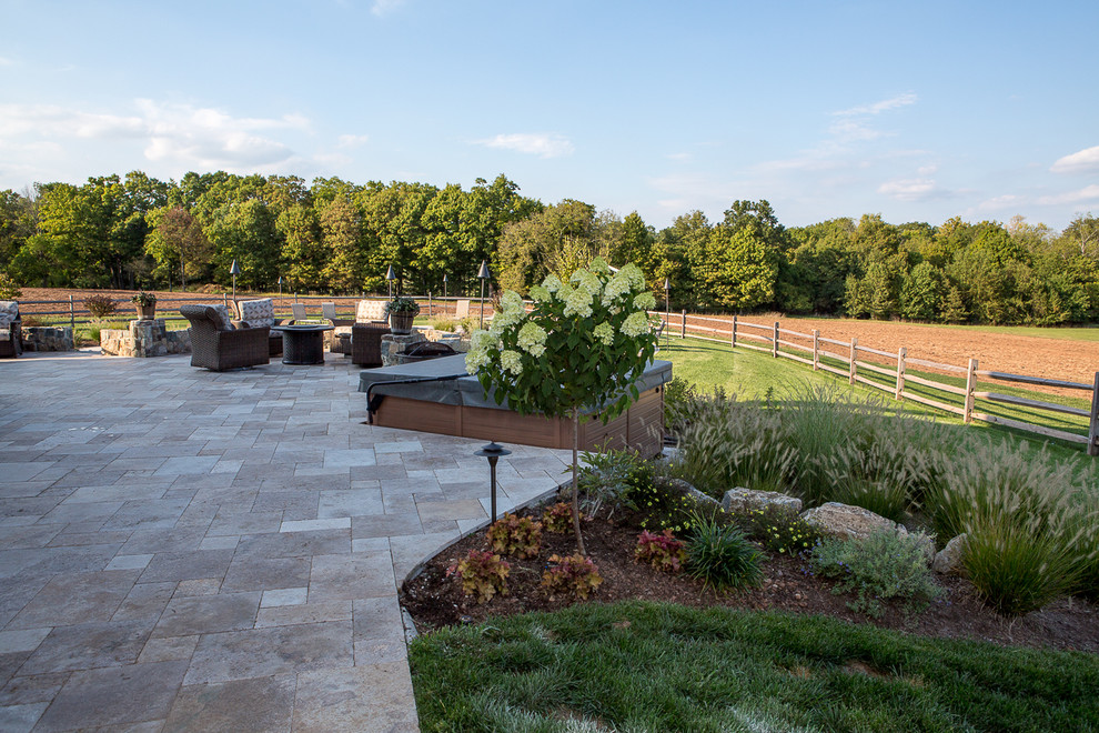 Photo of a large rural back patio in New York with natural stone paving.
