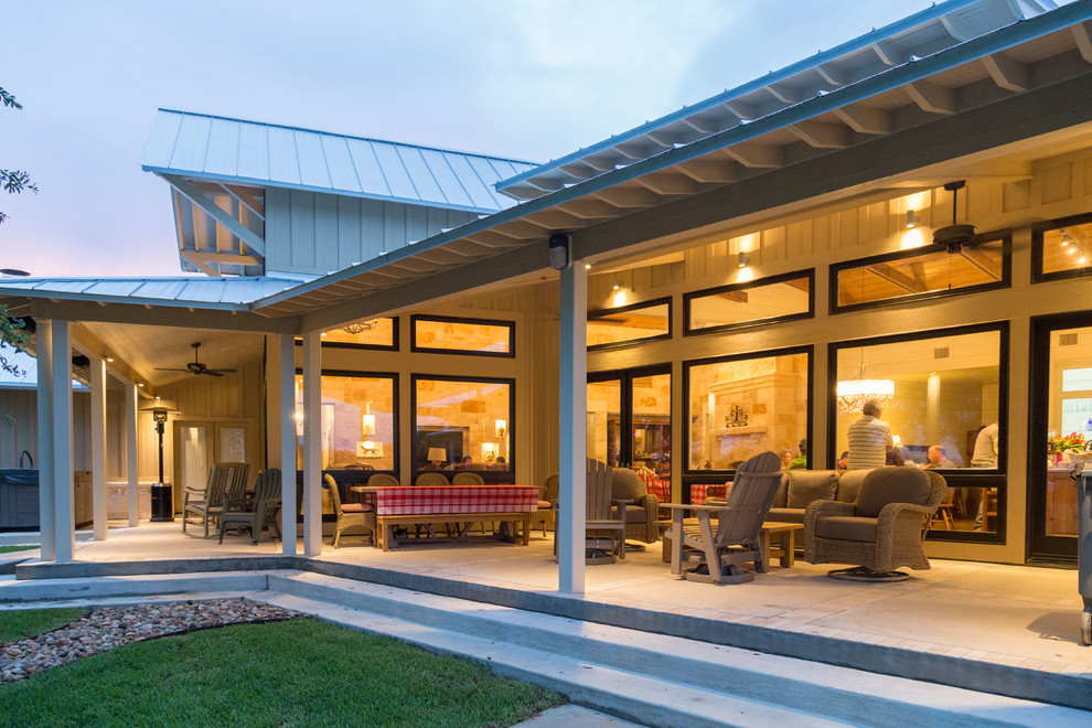 Esempio di un patio o portico country di medie dimensioni e dietro casa con lastre di cemento e un tetto a sbalzo