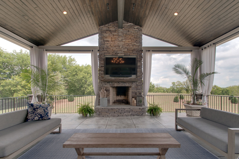 Cette photo montre une grande terrasse arrière rétro avec une cuisine d'été, une dalle de béton et une extension de toiture.