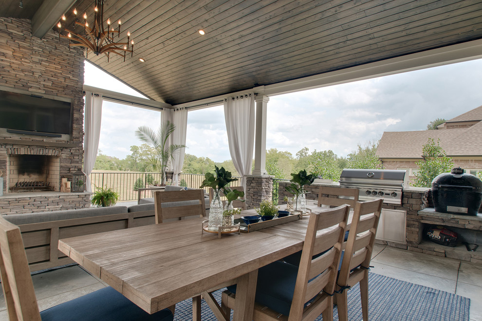 Aménagement d'une grande terrasse arrière rétro avec une cuisine d'été, une dalle de béton et une extension de toiture.