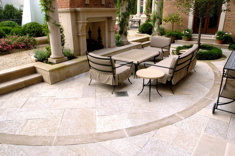 This is an example of an expansive classic courtyard patio in Chicago with natural stone paving, no cover and a fire feature.