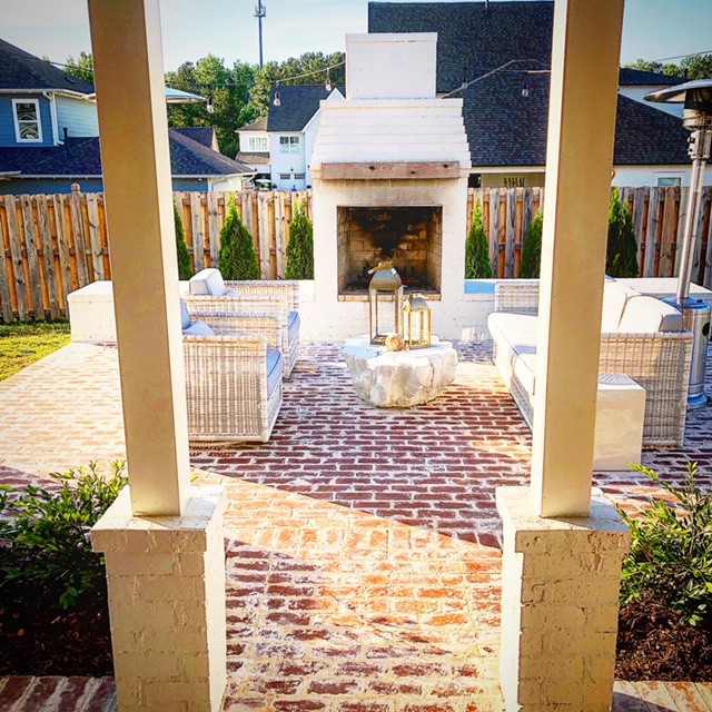 Large romantic back patio in Birmingham with a fireplace and brick paving.