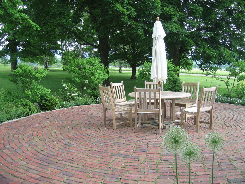 Inspiration for a mid-sized farmhouse backyard brick patio remodel in DC Metro with no cover