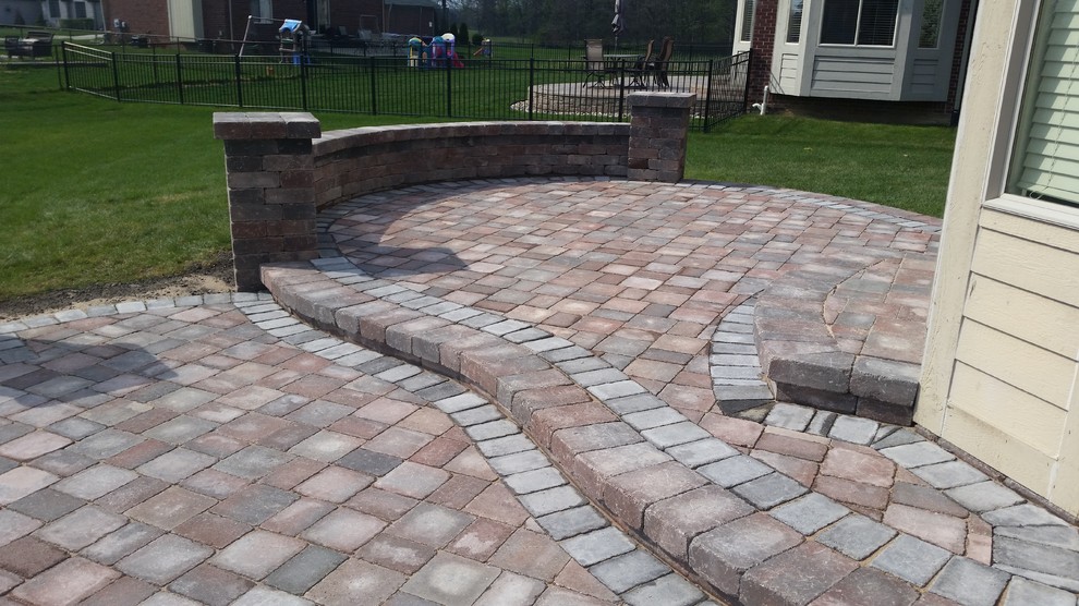 This is an example of a medium sized contemporary back patio in Detroit with brick paving and no cover.