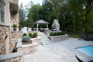 Brick paver pool deck, outdoor fireplace and kitchen on raised