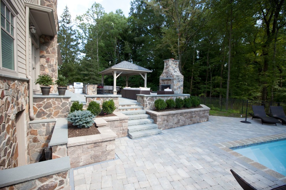 Cette image montre une grande terrasse traditionnelle avec une cuisine d'été, une cour, des pavés en brique et un gazebo ou pavillon.