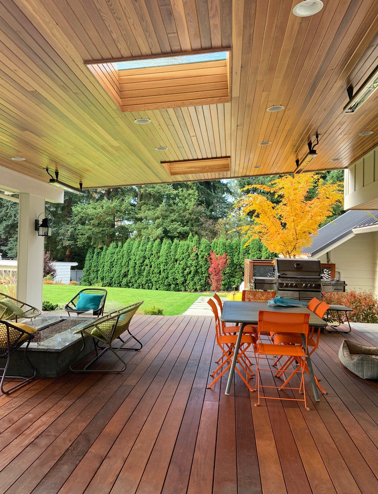 Cette image montre une terrasse en bois arrière design avec une cheminée.