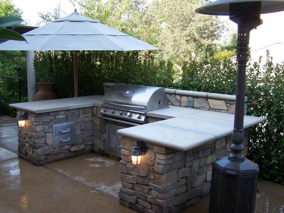 Cette photo montre une terrasse arrière méditerranéenne de taille moyenne avec une cuisine d'été, du béton estampé et une pergola.