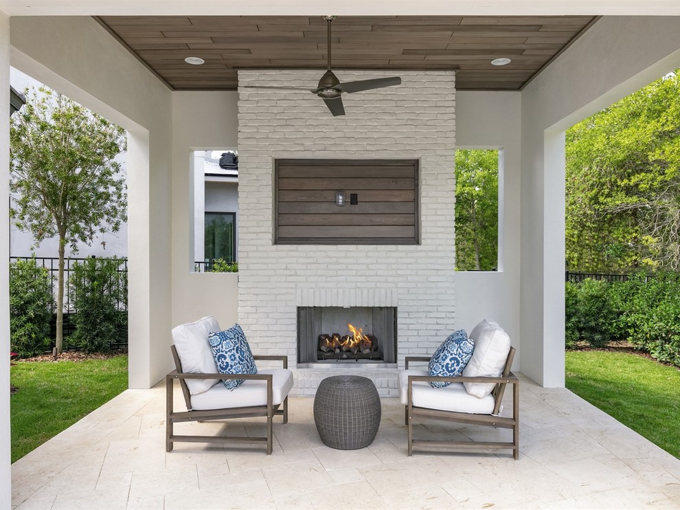 Inspiration for a mid-sized transitional backyard stone patio remodel in Orlando with a gazebo and a fireplace