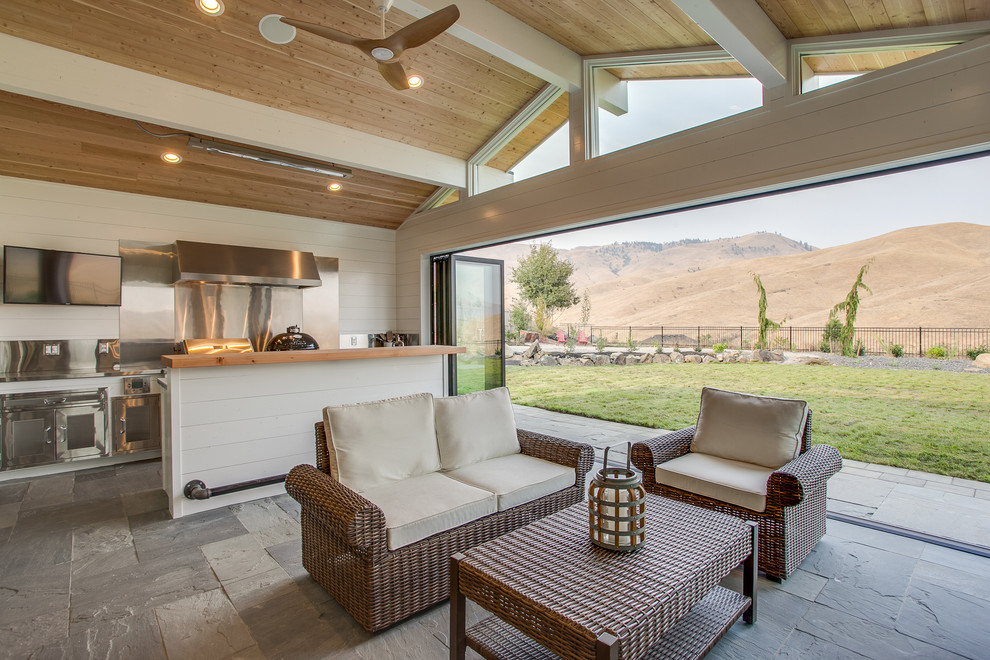 Идея дизайна: двор на заднем дворе в стиле кантри с летней кухней, покрытием из плитки и навесом