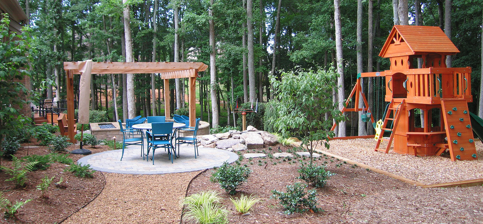 Inspiration for a large contemporary backyard brick patio remodel in Charlotte with a fire pit and a pergola