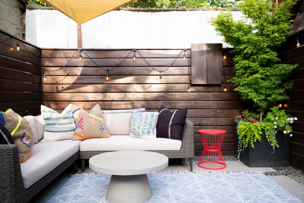 Small trendy backyard concrete patio container garden photo in Austin with an awning