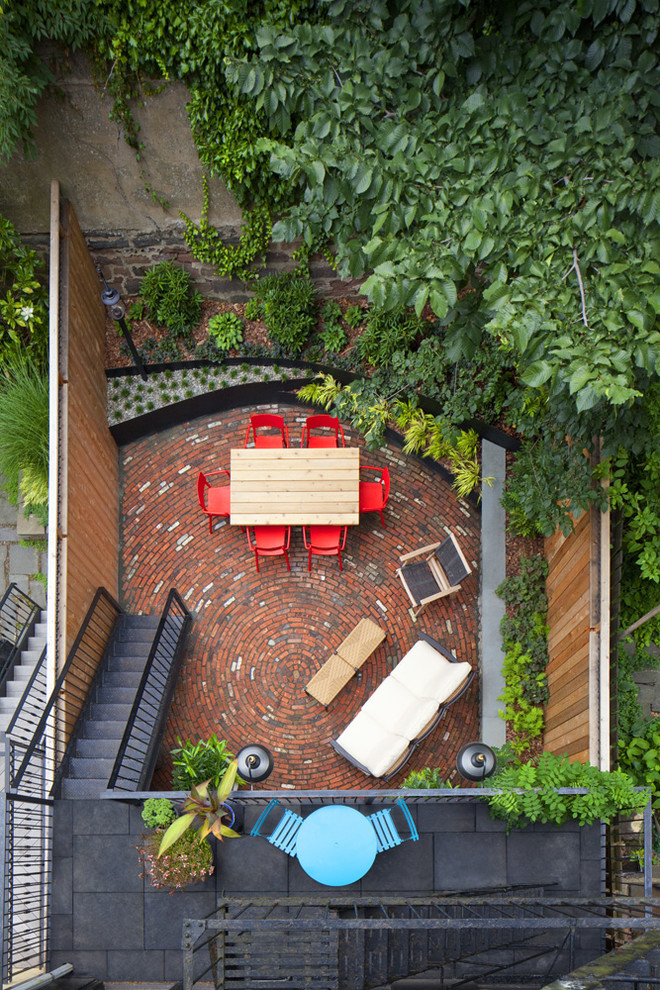 Kleiner Moderner Patio hinter dem Haus mit Pflastersteinen in New York
