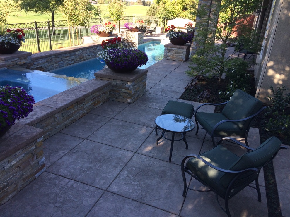 Photo of a large classic back patio in Sacramento with stamped concrete and no cover.