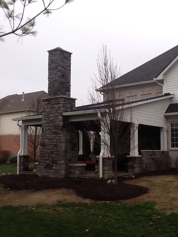 Mid-sized elegant backyard concrete paver patio photo in Indianapolis with a fire pit and a roof extension