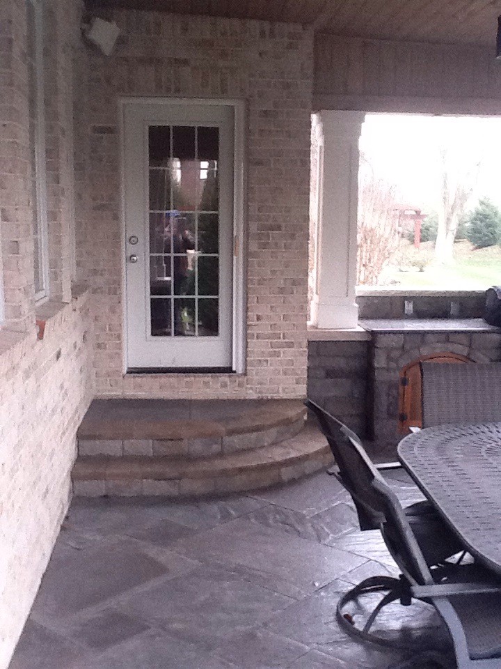 Aménagement d'une terrasse arrière classique de taille moyenne avec un foyer extérieur, des pavés en béton et une extension de toiture.