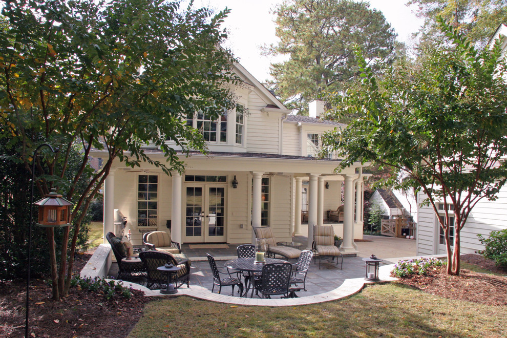 This is an example of a medium sized traditional back patio in Atlanta with concrete paving and a roof extension.