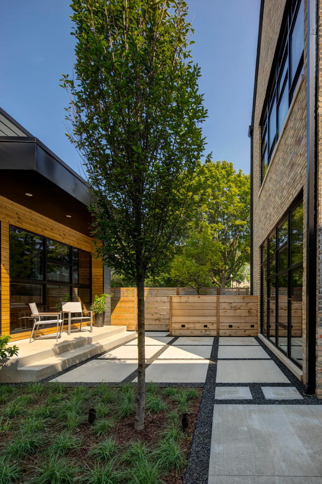 Diseño de patio actual de tamaño medio en patio trasero y anexo de casas con losas de hormigón