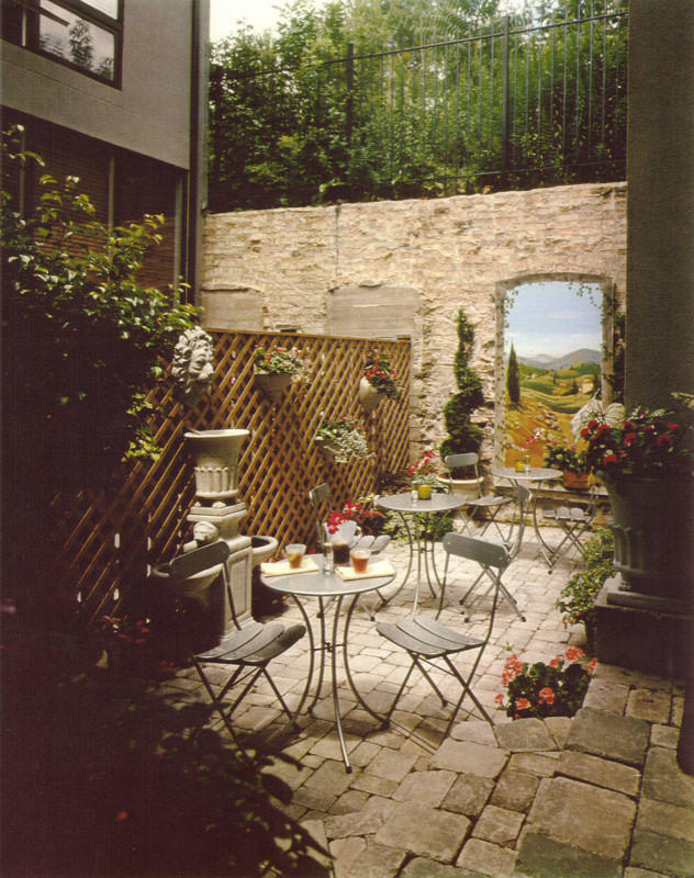 Ispirazione per un patio o portico classico di medie dimensioni e in cortile con un giardino in vaso, piastrelle e nessuna copertura