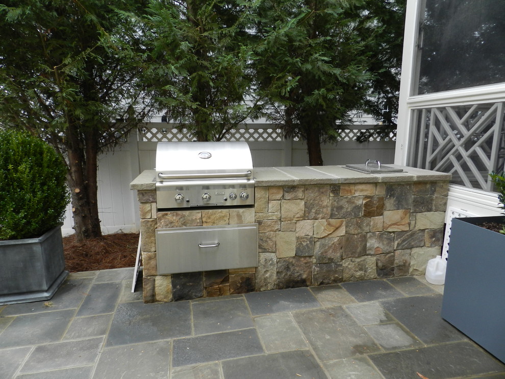 Design ideas for a small retro back patio in Raleigh with an outdoor kitchen, natural stone paving and no cover.