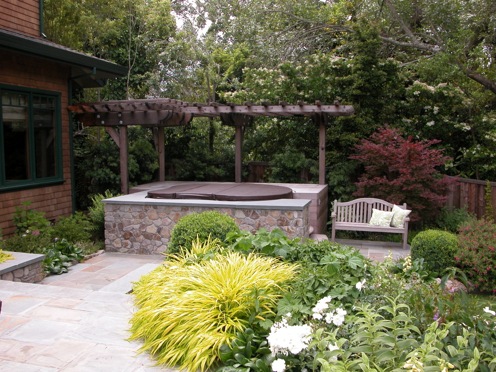 Esempio di un patio o portico minimal di medie dimensioni e dietro casa con fontane, pavimentazioni in pietra naturale e una pergola
