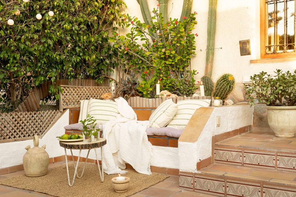 Cette image montre une terrasse avec des plantes en pots méditerranéenne avec du carrelage et aucune couverture.