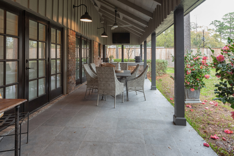 Photo of a medium sized mediterranean back patio in Houston with tiled flooring and an awning.