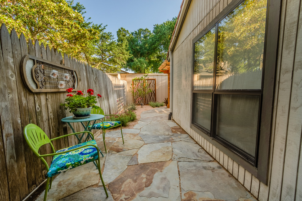 Patio - mid-sized southwestern backyard stone patio idea in Dallas with a pergola