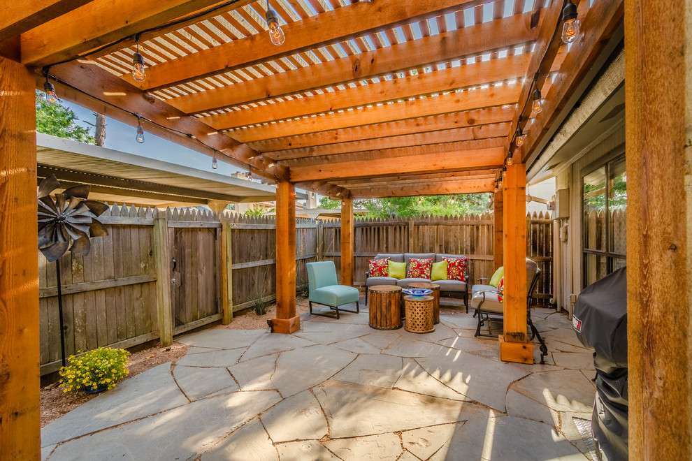 Foto di un patio o portico stile americano di medie dimensioni e dietro casa con pavimentazioni in pietra naturale e una pergola