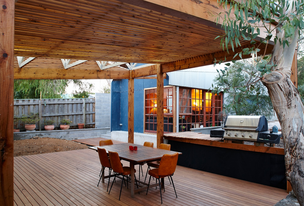 Idee per un patio o portico industriale dietro casa con pedane e un tetto a sbalzo