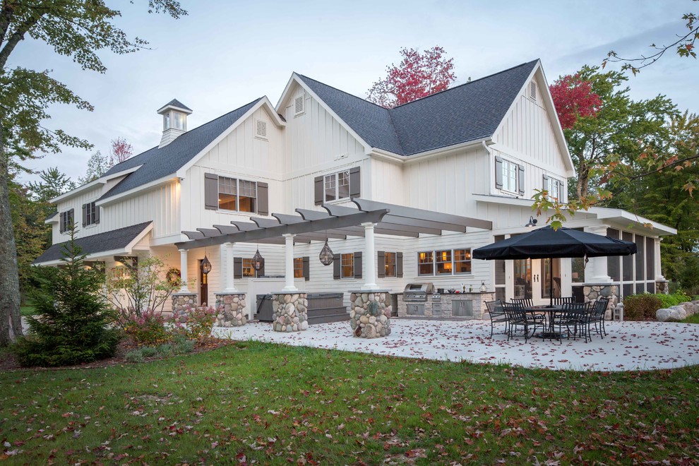 Inspiration for a large traditional back patio in Other with an outdoor kitchen, concrete slabs and a pergola.