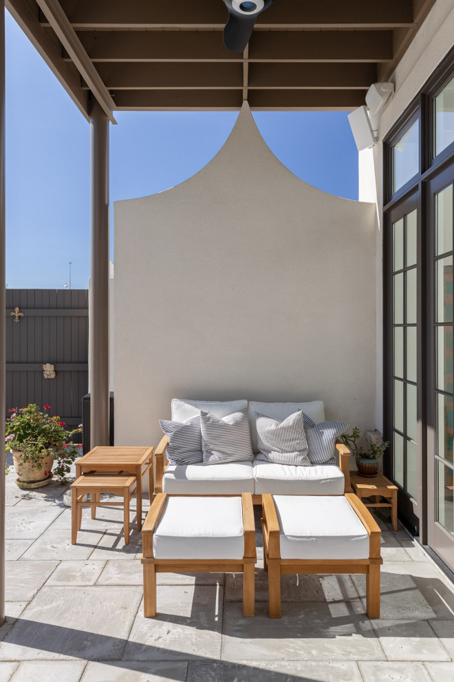 Esempio di un piccolo patio o portico contemporaneo in cortile con un focolare, pavimentazioni in cemento e un parasole