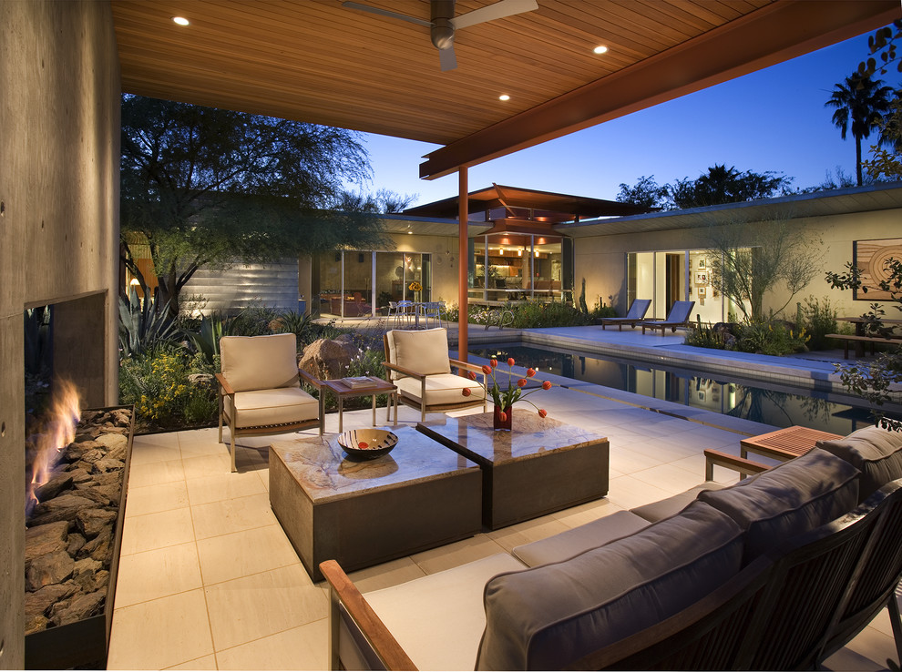 Réalisation d'une terrasse design avec une cour et un foyer extérieur.