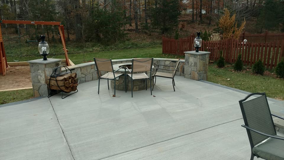 Photo of a large classic back patio in DC Metro with a fire feature, natural stone paving and no cover.