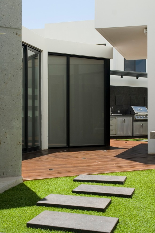 Diseño de patio actual grande sin cubierta en patio lateral con jardín vertical y entablado