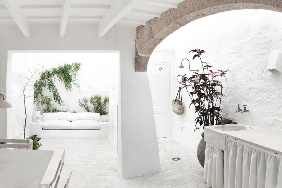 Esempio di un patio o portico mediterraneo di medie dimensioni e in cortile con un giardino in vaso e un tetto a sbalzo