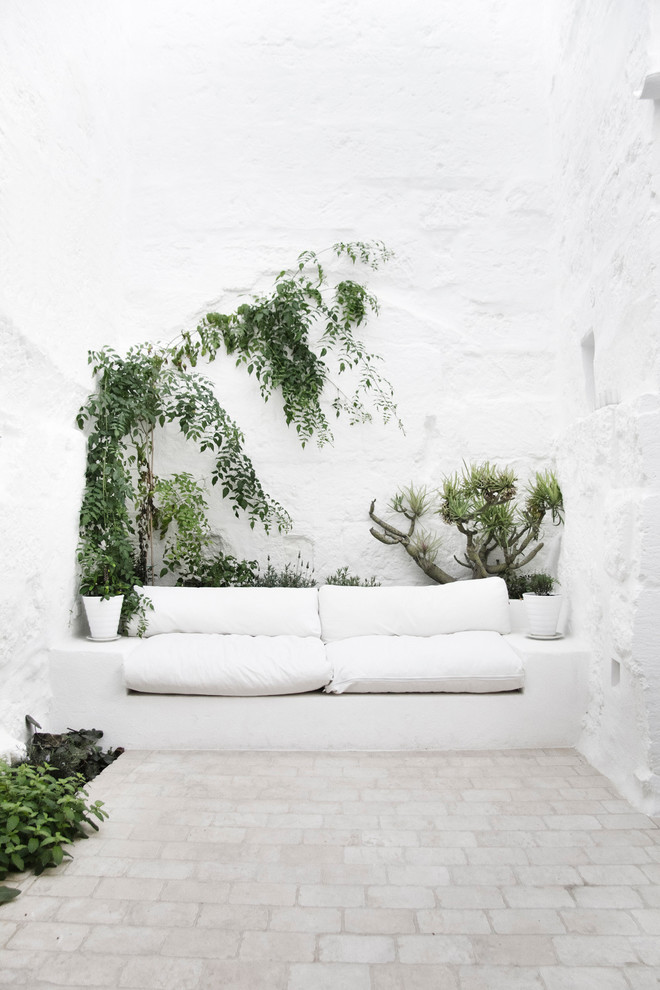 На фото: двор среднего размера на внутреннем дворе в средиземноморском стиле без защиты от солнца