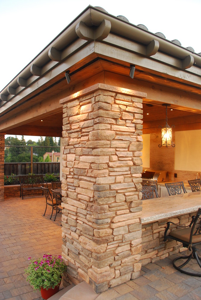 Exemple d'une terrasse arrière chic de taille moyenne avec une cuisine d'été, des pavés en béton et un gazebo ou pavillon.