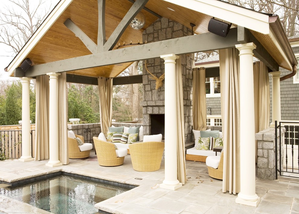 Idée de décoration pour une terrasse arrière marine avec un gazebo ou pavillon, un foyer extérieur et des pavés en pierre naturelle.