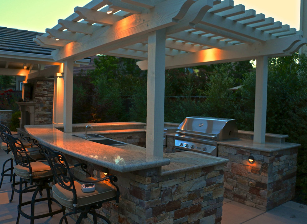 Large arts and crafts backyard concrete paver patio kitchen photo in San Francisco with a pergola