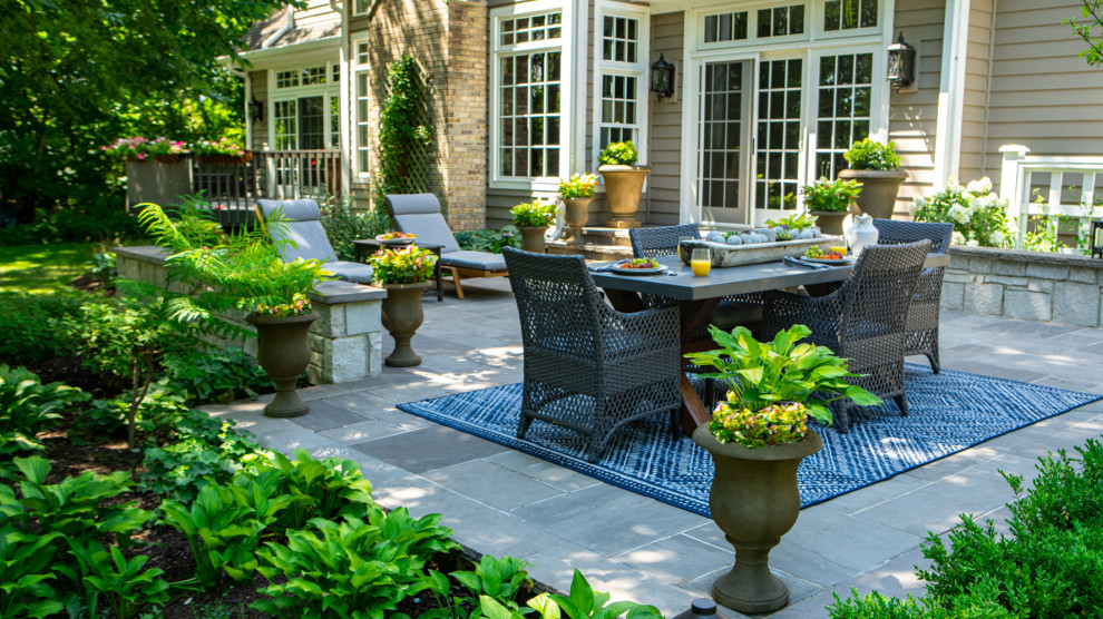 Diseño de patio clásico grande sin cubierta en patio trasero con chimenea y adoquines de piedra natural